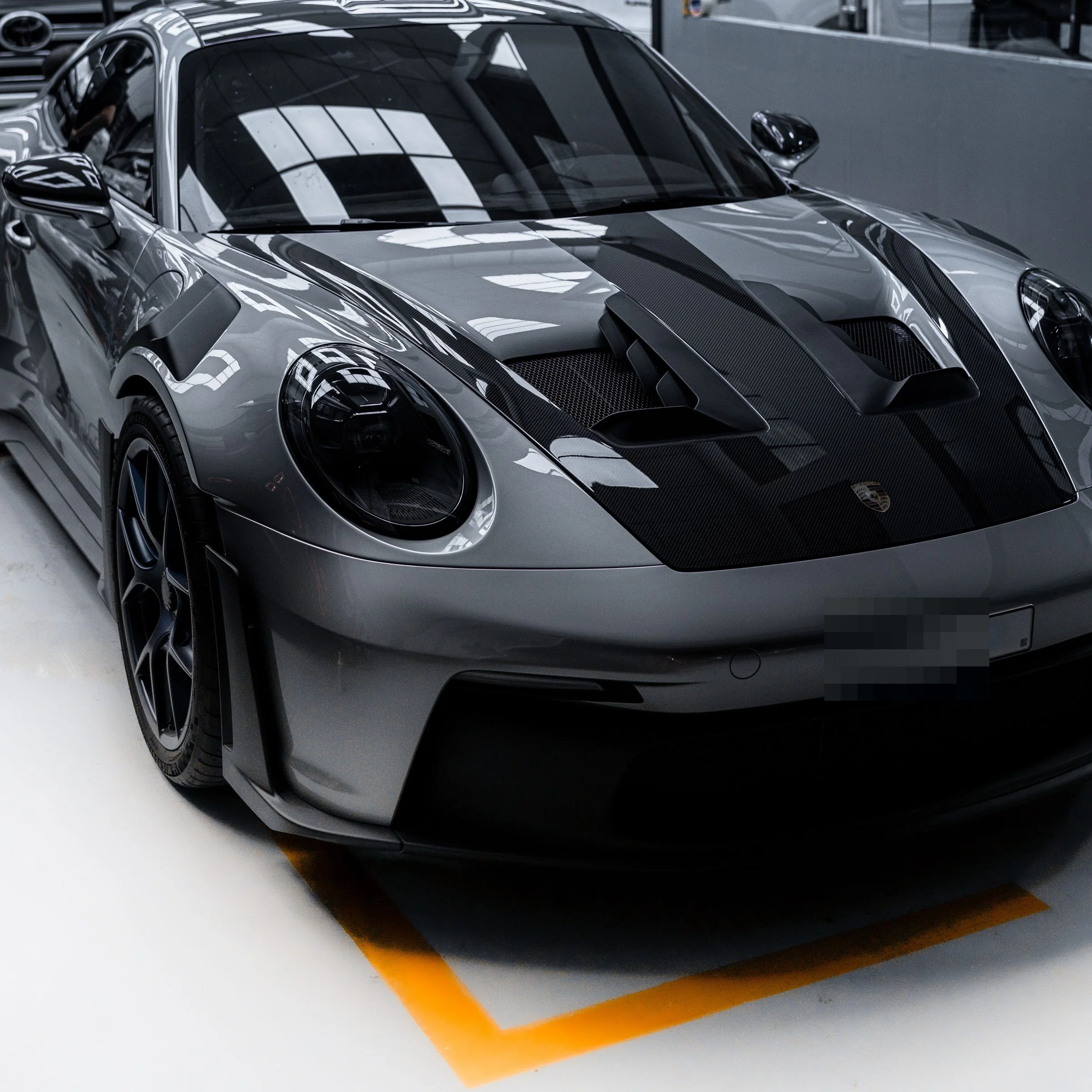 A grey Porsche 911 GT3 RS in a bay, seen from above